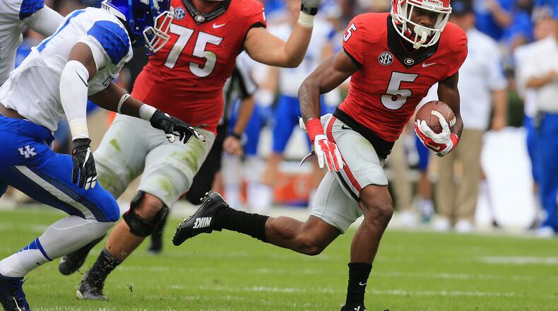 Georgia's Terry Godwin, taking the snap as quarterback, runs away from Kentucky defenders for a 7-0 lead during the first quarter on Saturday, Nov. 7, 2015 in Athens. Curtis Compton / ccompton@ajc.com