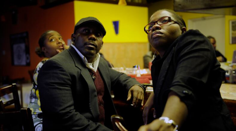 From left, Haitians Kevin Jeudy, 32, of Alpharetta, and Fabiola Guerrier, 26, of Conyers, watch news coverage of the magnitude 7 earthquake that hit their home yesterday at Cafe Fasika in Clarkston, Ga Wednesday, Jan 13, 2010. Guerrien says she came to the United States in 2000 and is still waiting to hear from her family who is still living there.