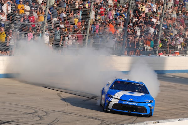Denny Hamlin celebrates with a burnout after winning a NASCAR Cup Series auto race at Dover Motor Speedway, Sunday, July 20, 2025, in Dover, Del. (AP Photo/Derik Hamilton)