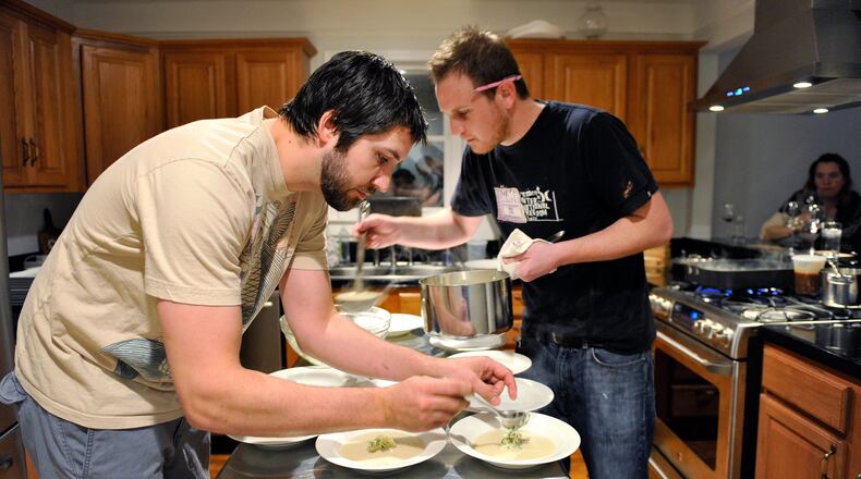 Hidinger (left) and Ben Barth (right) prepare fennel soup with apple relish at the supper club the Hidingers hosted in their Grant Park home in 2010.