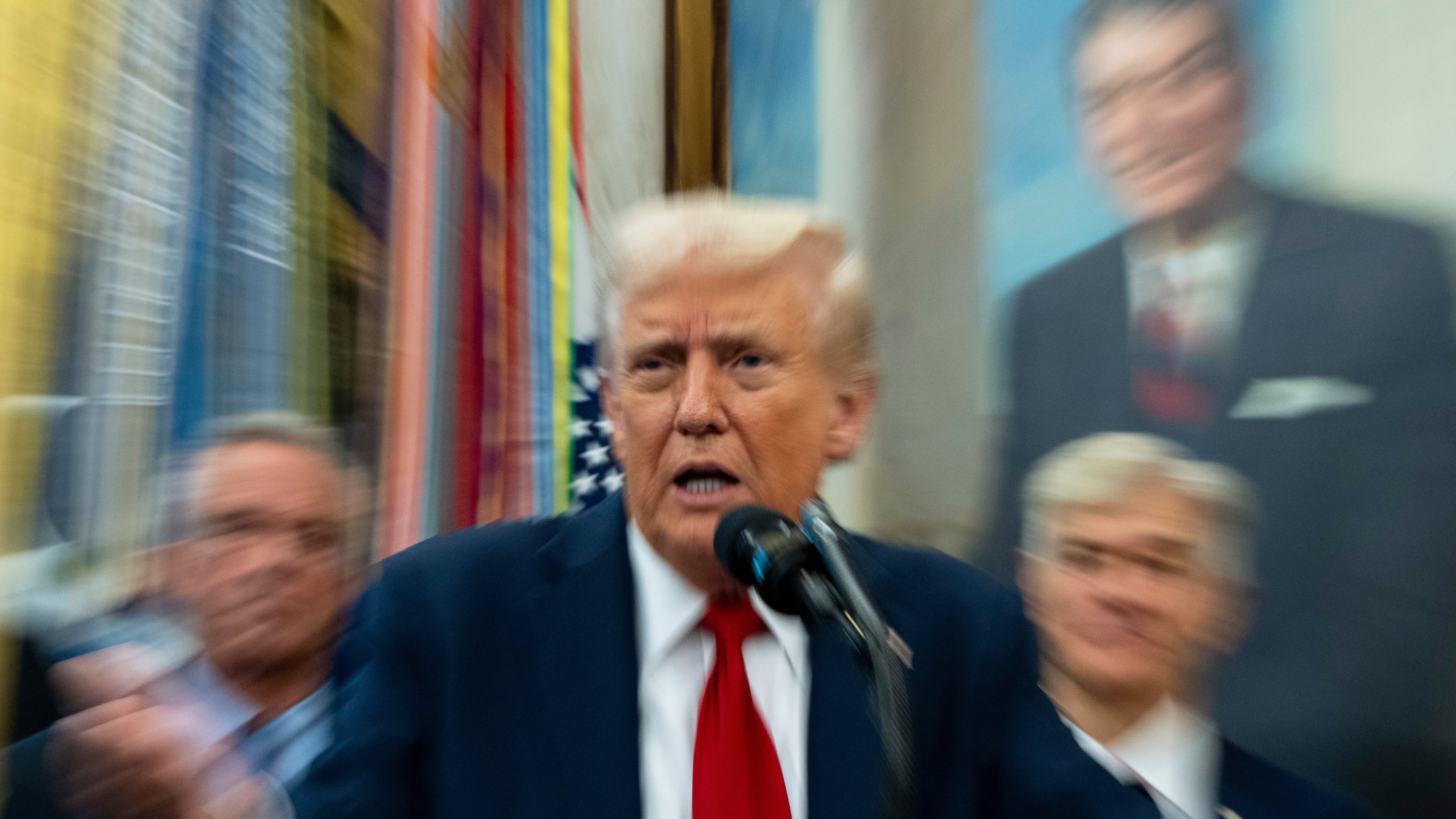 In this photo made with a slow shutter speed, President Donald Trump speaks in the Oval Office of the White House, Tuesday, Sept. 30, 2025, in Washington. (AP Photo/Alex Brandon)