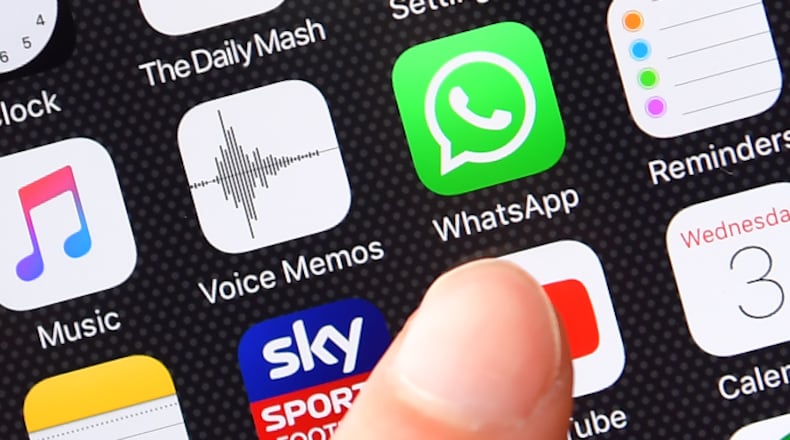 A persons finger is posed next to the Whatsapp app logo on an iPhone on August 3, 2016 in London, England.