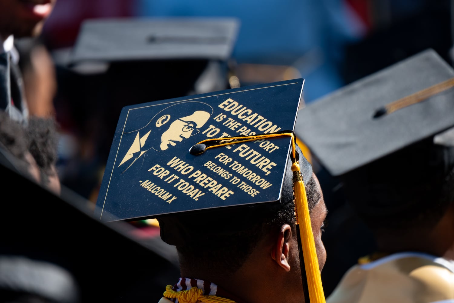 A Malcolm X quote is printed on a student’s mortarboard during the Morehouse College graduation Sunday, May 17, 2026. (Ben Gray for the AJC)