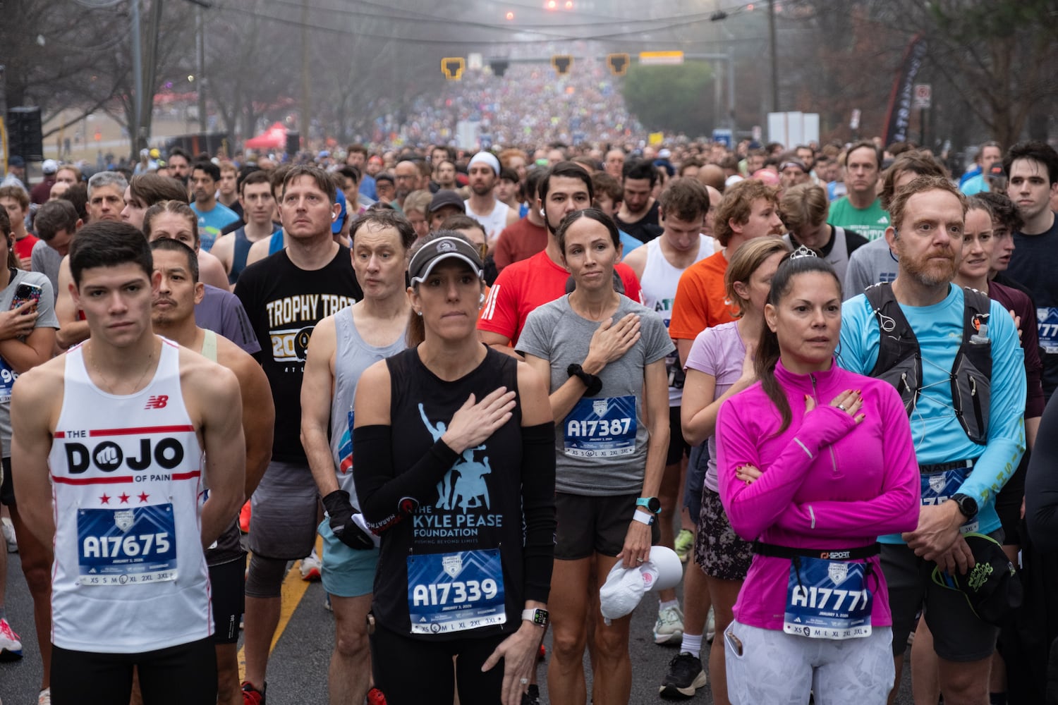 Runners listen to the national anthem before the start of the Polar Opposite Peachtree Road Race on Saturday, Jan. 3, 2026, in Atlanta. (Ben Gray for the AJC)