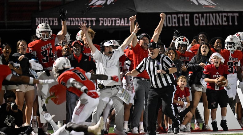 North Gwinnett players and coaches celebrate on the sideline after stopping Norcross on fourth down to secure victory against Norcross during a GHSA region football game in Suwanee, GA., on Friday, Oct. 25, 2024. (Jim Blackburn for the AJC)