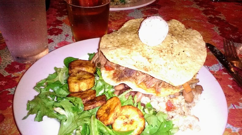 The adobo pork tostada at the Guadalupe Cafe in Sylva, served over beans and brown rice with a spicy roasted tomato-cumin sauce, goat cheese and a side of grilled plantains. CONTRIBUTED BY BLAKE GUTHRIE