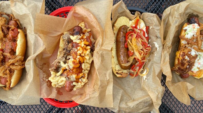 DBA is a barbecue mainstay, but it also offers quarter-pound beef frankfurters. Pictured from left are the stew dog, Mac Daddy, andouille dog and DBA dog. Ligaya Figueras/ligaya.figueras@ajc.com