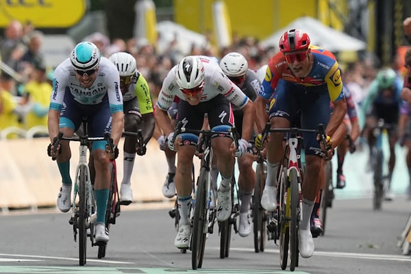 Belgium's Tim Merlier, center, and Italy's Jonathan Milan, right, sprint to the finish line during the third stage of the Tour de France cycling race over 178.3 kilometers (110.8 miles) with start in Valenciennes and finish in Dunkerque, France, Monday, July 7, 2025. (AP Photo/Thibault Camus)