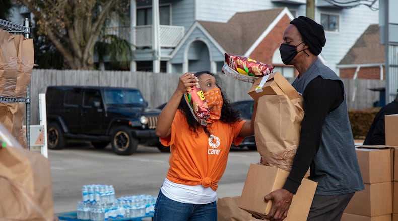 Gabby Dirden, a CARE contractor, helps Walter Ballard collect food and water for his family during Bethel's Heavenly Hands food and water distribution in Houston, Texas, on Feb. 25, 2021. Hundreds of people received much needed food and water. The need was especially great following the snowstorms that disrupted power and water service to much of Houston. Bethel's Heavenly Hands is a CARE partner. (Courtesy of Laura Noel/CARE)