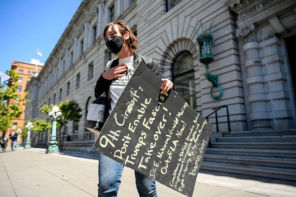 A demonstrator stands outside the 9th U.S. District Court of Appeals before a hearing regarding control of National Guard troops Tuesday, June 17, 2025, in San Francisco. (AP Photo/Noah Berger)