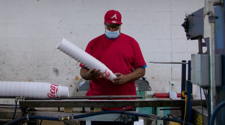 Rufus “Junior” Willis holding a stack of 44 ounce car cups coming off the WinCup assembly line in Stone Mountain. Despite talk of a recession, demand for its products still strong, the company says.