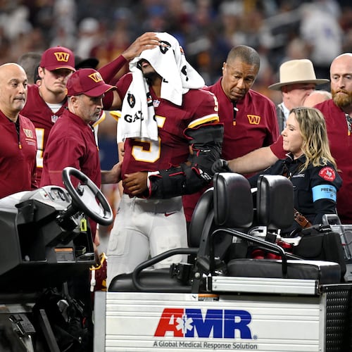 Trainers attend to Washington Commanders quarterback Jayden Daniels (5) after an apparent injury in the first half against the Dallas Cowboys during an NFL football game in Arlington, Texas, Sunday, Sept. 20, 2026. (AP Photo/Jessica Tobias)
