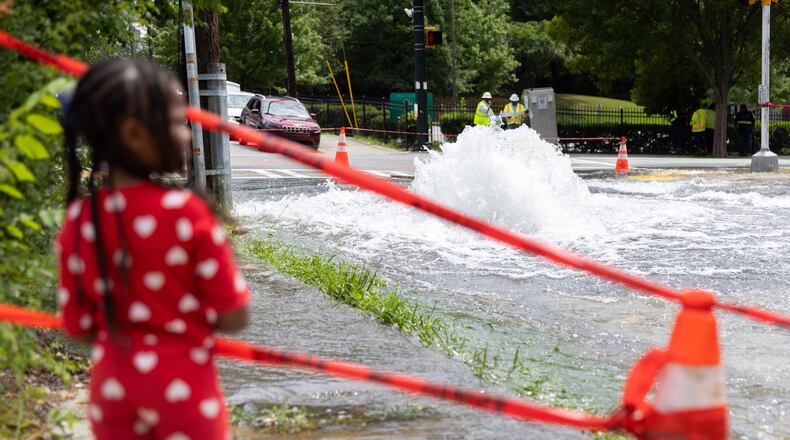 April Woods, 4, watches a water main break at Joseph E. Boone Boulevard and James P. Brawley Drive in Atlanta on May 31, 2024. (Arvin Temkar/The Atlanta Journal-Constitution/TNS)