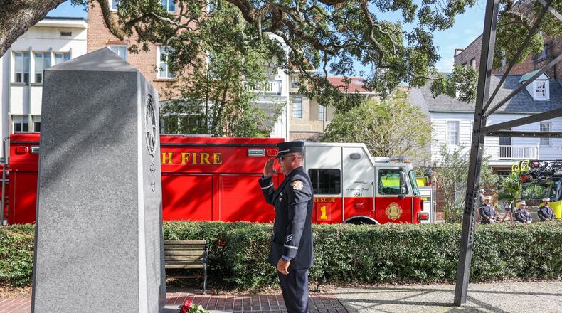 A firefighter salutes after placing a rose at the base of the firefighter memorial during the Savannah-Chatham Firefighters Memorial Service on Saturday, October 7, 2023.