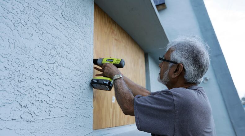 Ray Gohill, owner of the Sahara Motel, does some last minute boarding up of his windows Thursday, Oct. 6, 2016, in Daytona Beach, Fla. Hurrican Matthew continues to make a path for Florida's east coast. (AP Photo/Chris O'Meara)