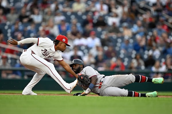 Atlanta Braves' Michael Harris II is tagged out by Washington Nationals third baseman José Tena while attempting to advance to third base on a fielder choice thrown by shortstop CJ Abrams on a ball hit by Nick Allen during the second inning of a baseball game in Washington, Tuesday, May 20, 2025. (AP Photo/Terrance Williams)