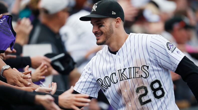 Fans congratulate Colorado Rockies third baseman Nolan Arenado after the Rockies defeated the Washington 12-0, in Denver.