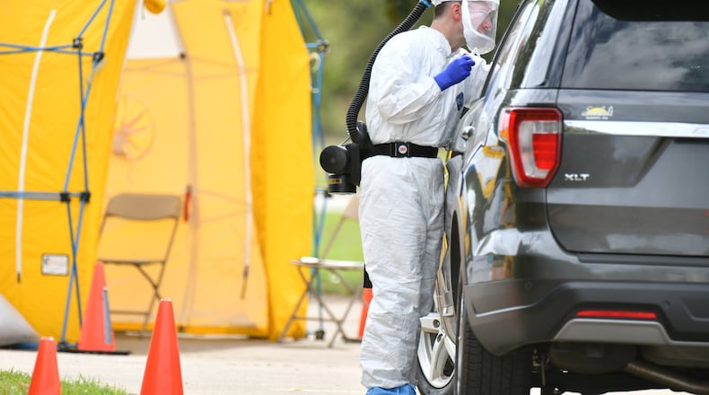A medical professional in protective equipment collects a sample from a potential COVID-19 patient at a Phoebe Putney Health System drive-through testing site in Albany on Tuesday, March 24, 2020. Well off the interstate some 180 miles south-southwest of Atlanta, Albany has struggled with an outbreak of the coronavirus. (HYOSUB SHIN / HYOSUB.SHIN@AJC.COM)