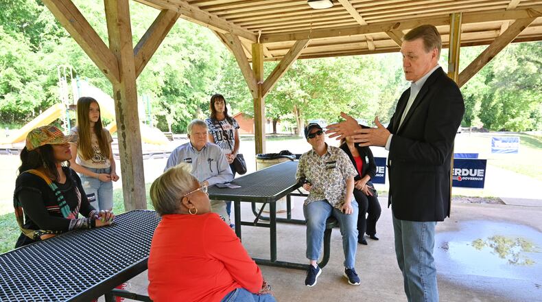Former U.S. Sen. David Perdue talks to his supporters at a campaign event earlier this month at Sell's Mill Park in Hoschton. Perdue, trying to unseat Gov. Brian Kemp in the GOP primary, has been trailing by double digits in polls while also lagging well behind in fundraising. His campaign, however, is looking for reasons to be optimistic as it analyzes data from the turnout during early voting. (Hyosub Shin / Hyosub.Shin@ajc.com)