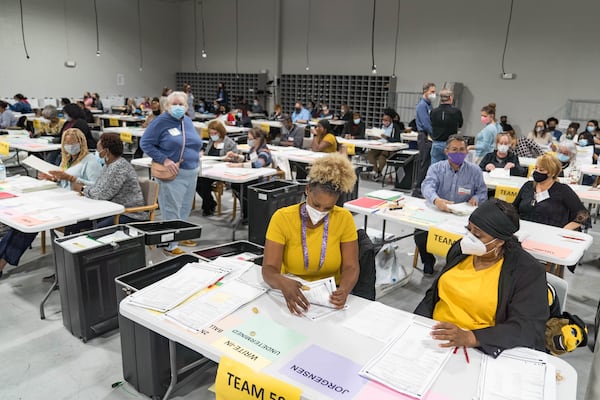 Gwinnett County election workers handle ballots as part of the recount for the 2020 presidential election at the Beauty P. Baldwin Voter Registrations and Elections Building on November 16, 2020 in Lawrenceville, Georgia.   (Megan Varner/Getty Images/TNS)
