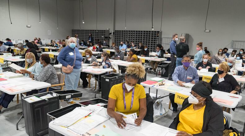 Gwinnett County election workers handle ballots as part of the recount for the 2020 presidential election at the Beauty P. Baldwin Voter Registrations and Elections Building on November 16, 2020 in Lawrenceville, Georgia. Officials are hoping to finish the hand counting of ballots before the deadline on November 18. A winner has not been declared in Georgia, where President-elect Joe Biden leads President Donald Trump by 0.3 percentage points. (Megan Varner/Getty Images/TNS)