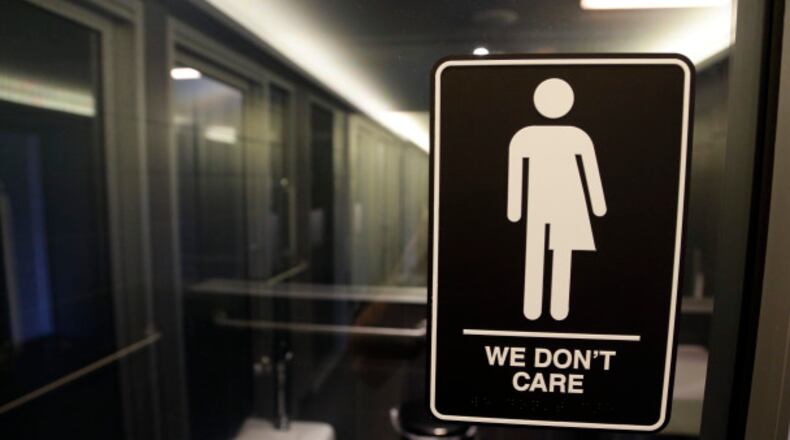 A sign is seen outside a restroom at 21c Museum Hotel in Durham, N.C. The state is in a legal battle over a state law that requires transgender people to use the public restroom matching their biological sex. The ADA-compliant bathroom signs were designed by artist Peregrine Honig. (AP Photo/Gerry Broome)