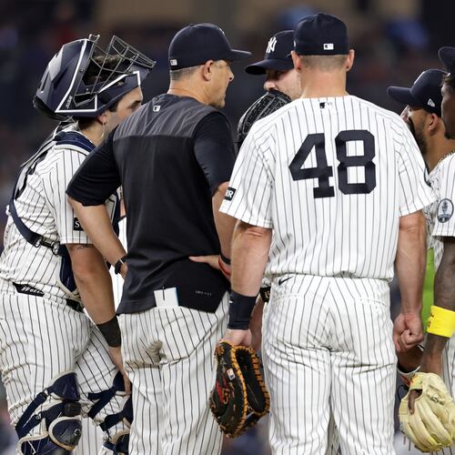 New York Yankees manager Aaron Boone, second left, confers with Gerrit Cole during the seventh inning of a baseball game against the Los Angeles Dodgers, Friday, July 17, 2026, in New York. (AP Photo/Adam Hunger)