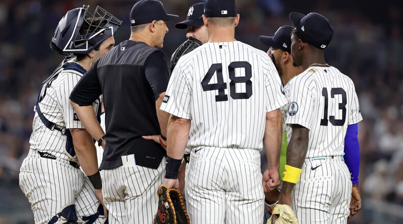 New York Yankees manager Aaron Boone, second left, confers with Gerrit Cole during the seventh inning of a baseball game against the Los Angeles Dodgers, Friday, July 17, 2026, in New York. (AP Photo/Adam Hunger)