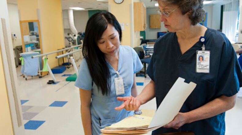 Occupational therapist Linh Do (left) confers with Mary White, senior physical therapist, about a patient’s chart at the Marcus Stroke & Neuroscience Center in Atlanta. Learn about strokes on May 16 at Fayette Senior Services, The Life Enrichment Center, 4 Center Drive, Fayetteville during this free program. (Courtesy of Barry Williams)