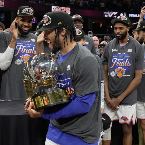 New York Knicks guard Jalen Brunson, center, holds the Eastern Conference Championship trophy after Game 4 in the Eastern Conference finals NBA basketball playoffs series against the Cleveland Cavaliers in Cleveland, Monday, May 25, 2026. (AP Photo/Sue Ogrocki)