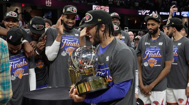 New York Knicks guard Jalen Brunson, center, holds the Eastern Conference Championship trophy after Game 4 in the Eastern Conference finals NBA basketball playoffs series against the Cleveland Cavaliers in Cleveland, Monday, May 25, 2026. (AP Photo/Sue Ogrocki)