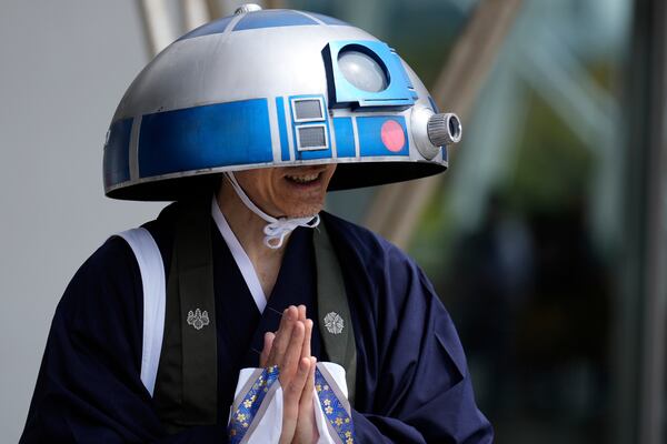 A Star Wars fan in an R2-D2 costume poses for a photo outside the venue during a fan convention called the Star Wars Celebration in Chiba, near Tokyo, Friday, April 18, 2025. (AP Photo/Hiro Komae)