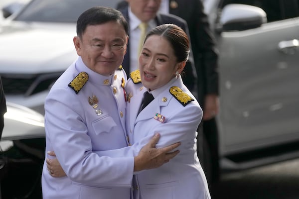 FILE - Thailand's former Prime Minister Thaksin Shinawatra, left, hugs his daughter and newly elected Prime Minister Paetongtarn Shinawatra before the royal endorsement ceremony appointing Paetongtarn as Thailand's new prime minister at Pheu Thai party headquarters in Bangkok, Thailand, on Aug. 18, 2024. (AP Photo/Sakchai Lalit, File)