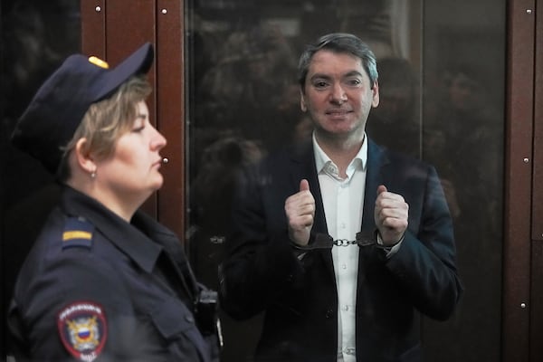 Grigory Melkonyants, co-chair of Russia's leading independent election monitoring group Golos looks at the media as he stands in a cage in a courtroom prior to a hearing in Basmanny district court in Moscow, Russia, Wednesday, May 14, 2025. (AP Photo/Alexander Zemlianichenko)