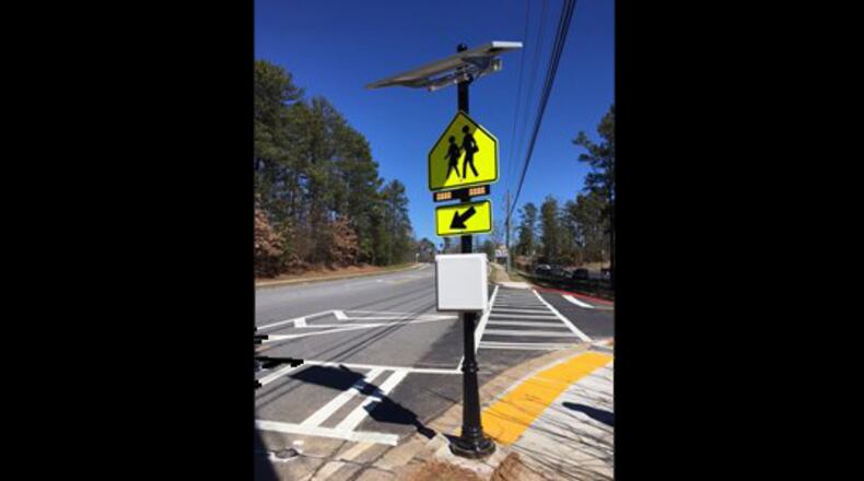 A new crosswalk on Buice Road in Johns Creek features the city’s first “Rectangular Rapid Flashing Beacons” to warn motorists of pedestrians crossing. CITY OF JOHNS CREEK