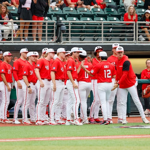Georgia Bulldogs pitcher Caden Aoki receives high-fives after finishing the fifth inning of Sunday's NCAA Regional final game. (Miguel Martinez/AJC)