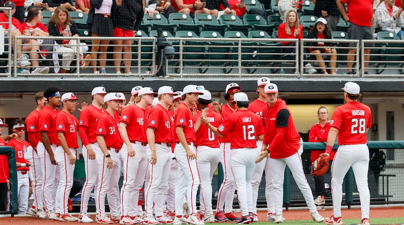 Georgia Bulldogs pitcher Caden Aoki receives high-fives after finishing the fifth inning of Sunday's NCAA Regional final game. (Miguel Martinez/AJC)