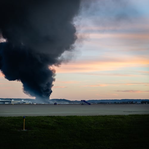 A plume of smoke rises from the site of a UPS cargo plane crash at Louisville Muhammad Ali International Airport on Tuesday, Nov. 4, 2025, in Louisville, Ky. (AP Photo/Jon Cherry)