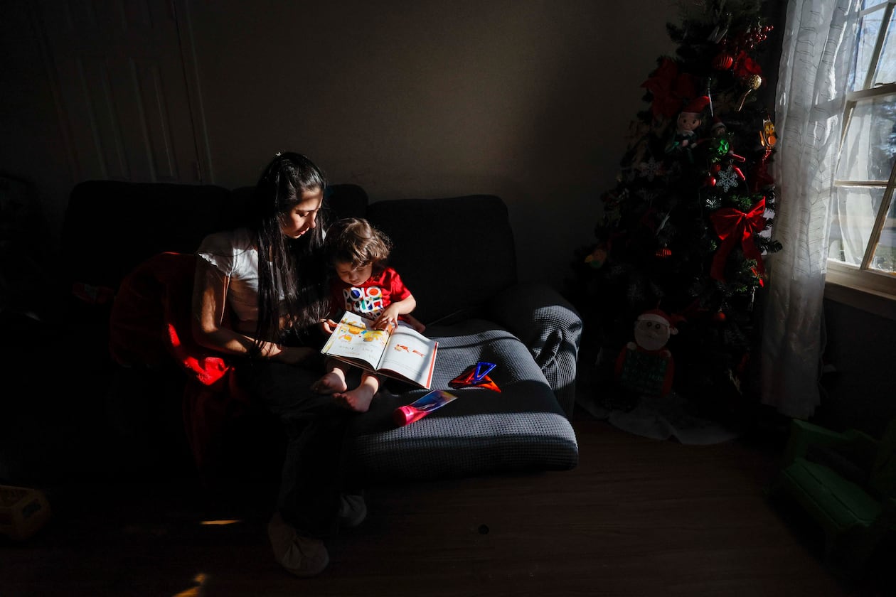 Ceudy Gutierrez reads a book to her 2-year-old son, Matias, at their home in Buford, GA, on Tuesday, Nov. 18, 2025. Ceudy Gutierrez is struggling to make ends meet for herself and her three young kids following her husband’s ICE arrest earlier this fall. (Miguel Martinez/ AJC)