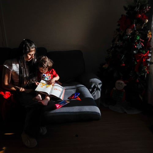 Ceudy Gutierrez reads a book to her 2-year-old son, Matias, at their home in Buford, GA, on Tuesday, Nov. 18, 2025. Ceudy Gutierrez is struggling to make ends meet for herself and her three young kids following her husband’s ICE arrest earlier this fall. (Miguel Martinez/ AJC)