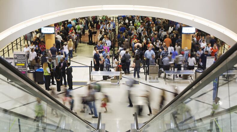 Crowds flow through Hartsfield-Jackson International Airport. Storage of surplus office furniture from the giant complex turned out to be costly. (AP Photo/David Goldman)