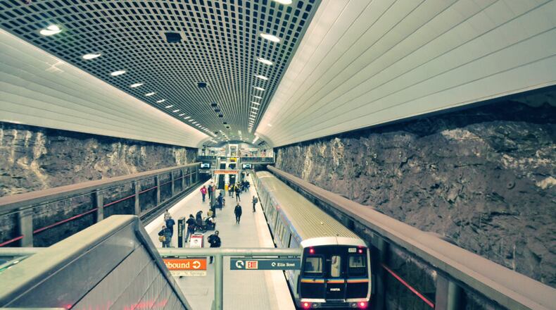 A view of an underground train station with people walking around.