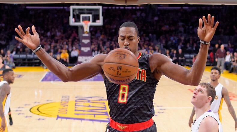 Atlanta Hawks center Dwight Howard, center, dunks as Los Angeles Lakers center Timofey Mozgov, lower right, of Russia, and Los Angeles Lakers guard Nick Young, upper right, watch during the first half of an NBA basketball game, Sunday, Nov. 27, 2016, in Los Angeles. (AP Photo/Mark J. Terrill)