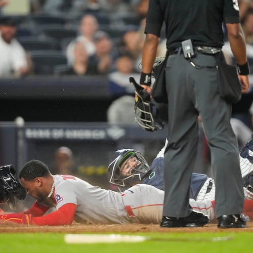 Boston Red Sox' Ceddanne Rafaela is tagged out by New York Yankees catcher Austin Wells at home plate on a double play during the seventh inning of a baseball game, Friday, Aug. 28, 2026, in New York. (AP Photo/Yuki Iwamura)