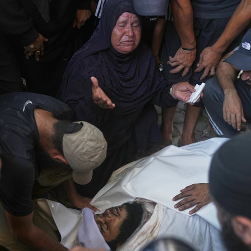 Relatives and friends grieve over the body of Hassan Qahman at a hospital morgue after he was killed in an Israeli airstrike in Gaza City, Saturday, Aug. 1, 2026. (AP Photo/Jehad Alshrafi)