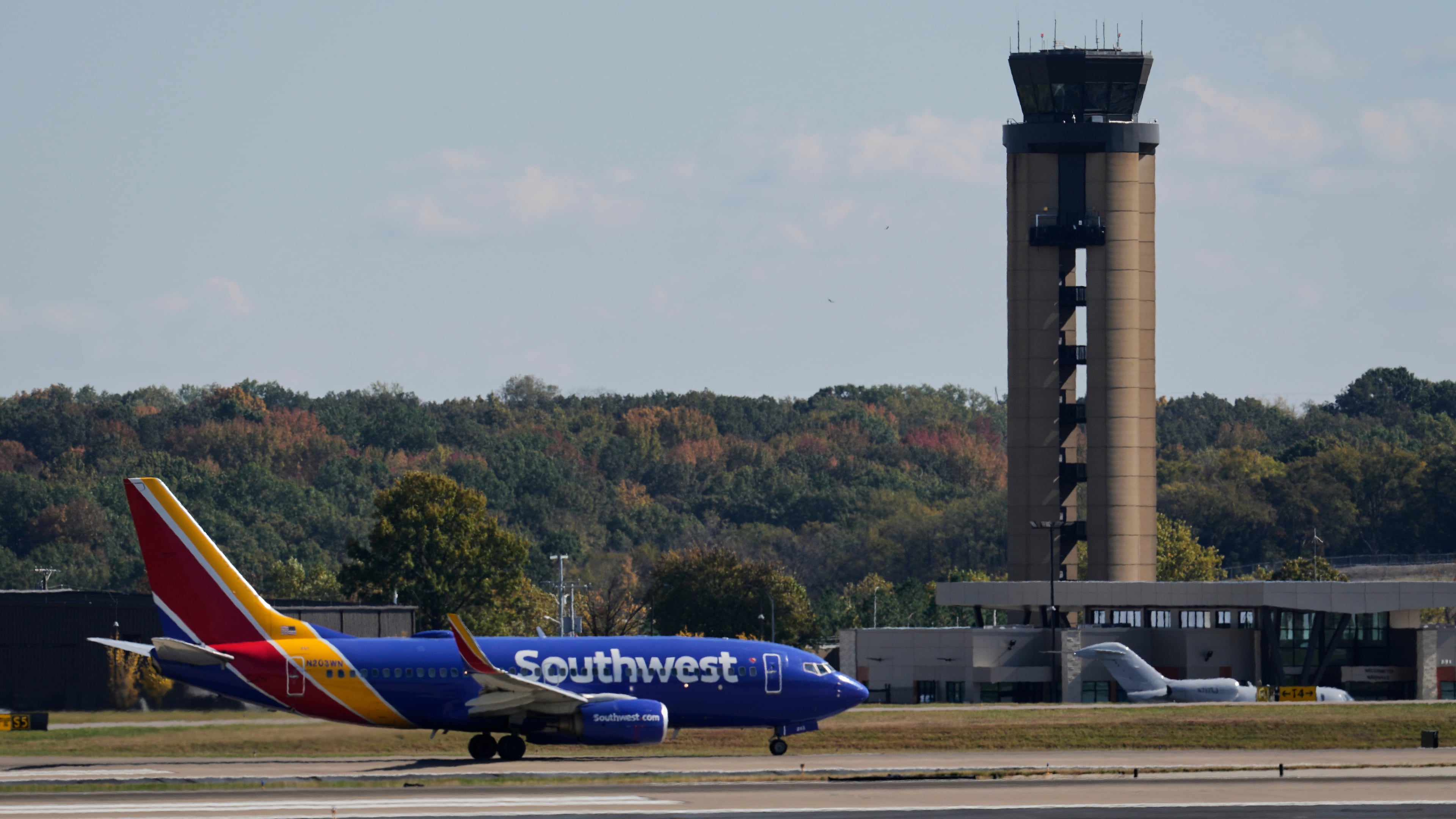 A plane taxis past the control tower before takeoff at the Nashville International Airport, Friday, Oct. 31, 2025, in Nashville, Tenn. (AP Photo/George Walker IV)