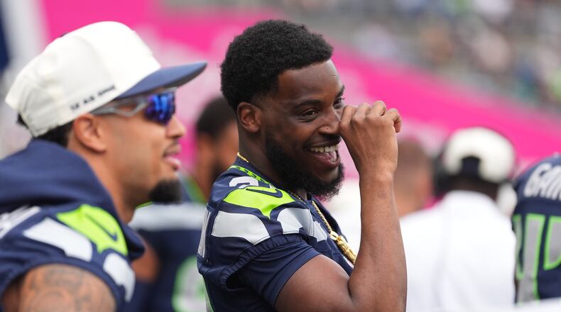 Seattle Seahawks cornerback Devon Witherspoon interacts with teammates on the sideline in the first half of an NFL preseason football game against the Dallas Cowboys, Saturday, Aug. 15, 2026, in Seattle. (AP Photo/Lindsey Wasson)