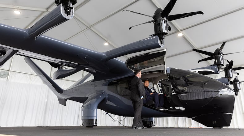 Douglas Hayes, staff manufacturing project manager, and Joshua Alconaba, senior production specialist, appear by Archer’s Midnight electric vertical take-off and landing (eVTOL) aircraft at DeKalb-Peachtree Airport in Atlanta on Thursday, July 25, 2024. (Arvin Temkar / AJC)