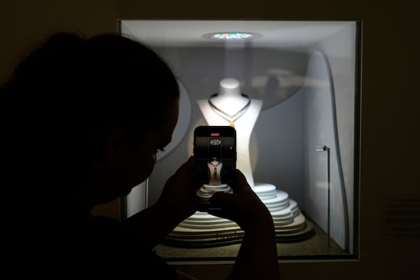 A visitor takes a photograph of 303.10 carat pear-shaped Fancy Deep Brownish Yellow Diamond during an exhibition in Abu Dhabi, United Arab Emirates, Tuesday, April 8, 2025. (AP Photo/Altaf Qadri)