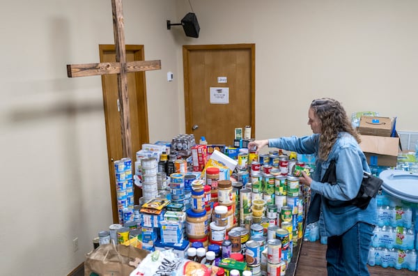 Parishioner Lisa Reitz gets cans of food and other donations ready for distribution at the Hunt Baptist Church following extreme flooding along the Guadalupe River on Sunday, July 6, 2025, in Hunt, Texas. (AP Photo/Rodolfo Gonzalez)